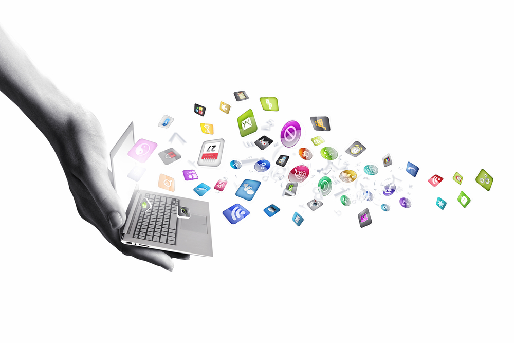 Close up of hand with laptop and media icons